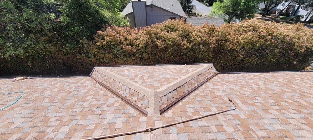 Aerial view of a sloped roof with unique triangular design and lush greenery in the background.